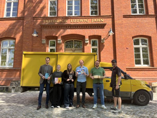 Schülerinnen und Lehrer des Gymnasiums Kyritz, darunter Schülersprecherin Malin Ribbe (Dritte von links), der stellvertretende Schuldirektor René Ide (Zweiter von rechts), und der Zusteller Mirko Barthel (rechts) I Foto: Deutsche Post DHL